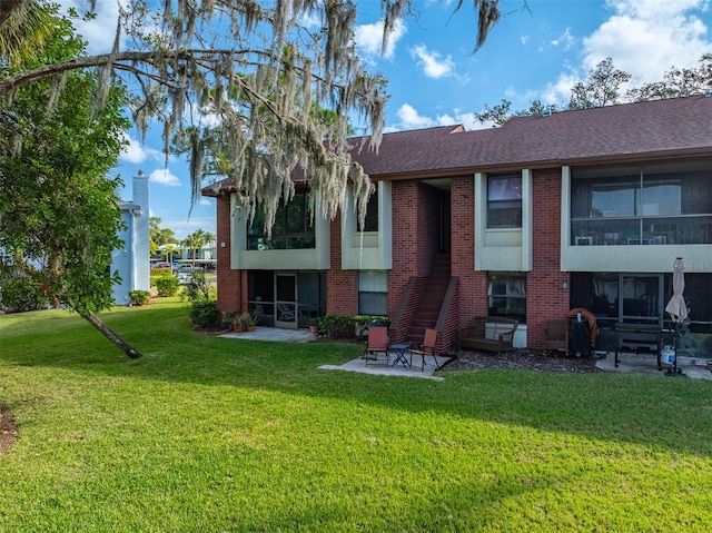 back of house with a patio and a yard