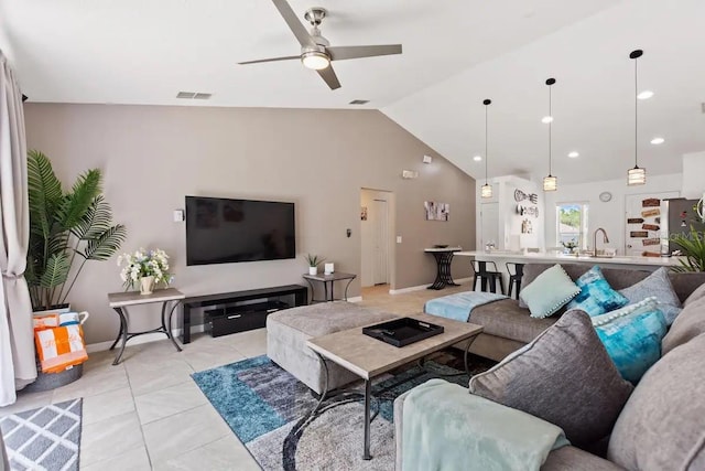 tiled living room featuring ceiling fan, lofted ceiling, and sink