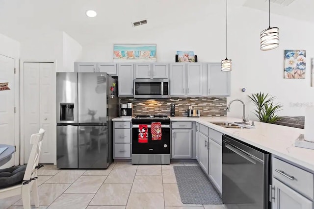 kitchen featuring decorative light fixtures, stainless steel appliances, gray cabinetry, and sink