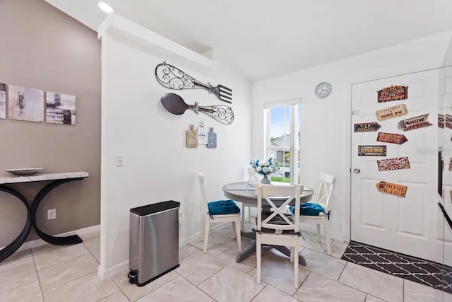 dining room with lofted ceiling and light tile patterned floors