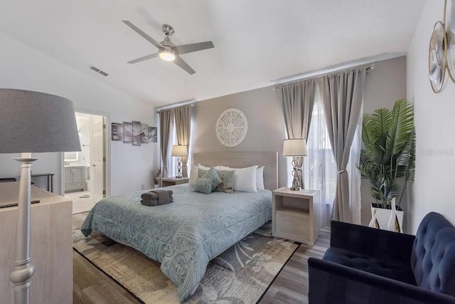 bedroom featuring connected bathroom, ceiling fan, hardwood / wood-style floors, and vaulted ceiling