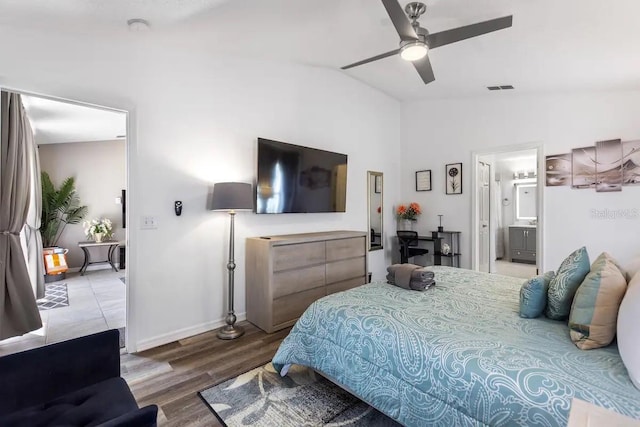 bedroom with hardwood / wood-style flooring, ceiling fan, ensuite bathroom, and vaulted ceiling