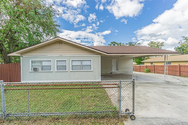 ranch-style house with a carport, cooling unit, and a front yard