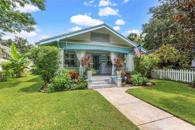 bungalow featuring a porch and a front lawn