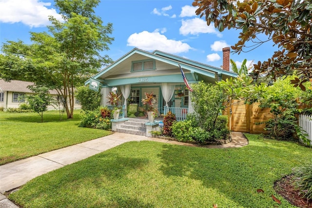 bungalow with covered porch and a front lawn