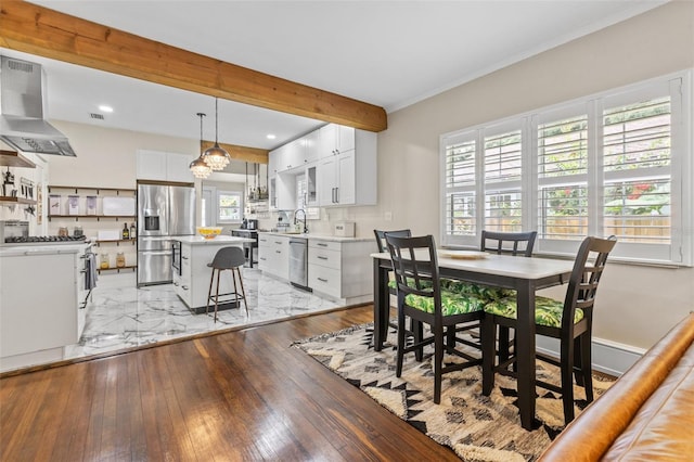 dining space featuring crown molding, sink, and light wood-type flooring