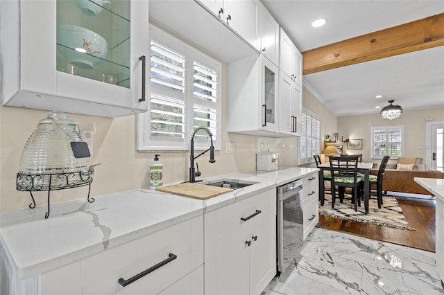 kitchen featuring white cabinets, stainless steel dishwasher, a healthy amount of sunlight, and sink