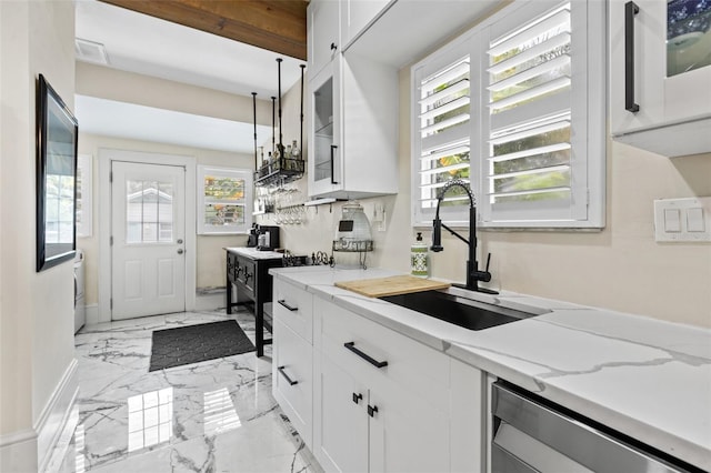 kitchen featuring sink, white cabinetry, and light stone counters