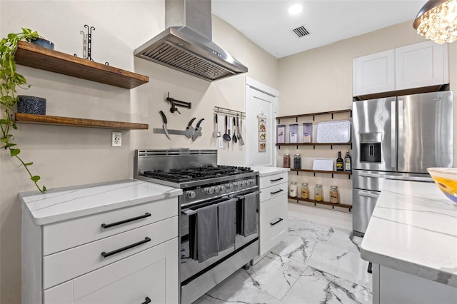 kitchen featuring light stone countertops, appliances with stainless steel finishes, extractor fan, an inviting chandelier, and white cabinetry