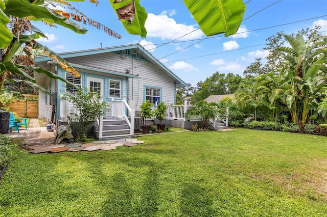 back of property with a lawn and a wooden deck