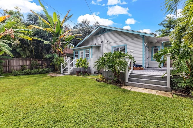 back of house with a lawn and a deck