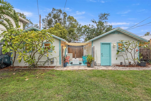 rear view of property featuring a lawn