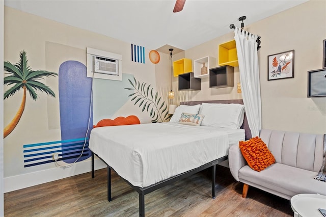 bedroom with hardwood / wood-style floors, ceiling fan, and a wall unit AC