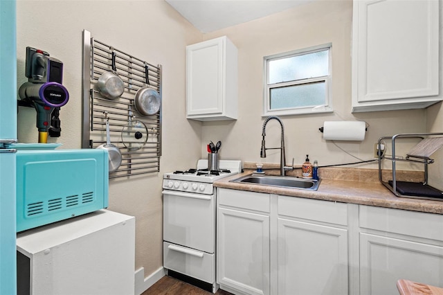 kitchen featuring white cabinets, white gas stove, dark hardwood / wood-style floors, and sink