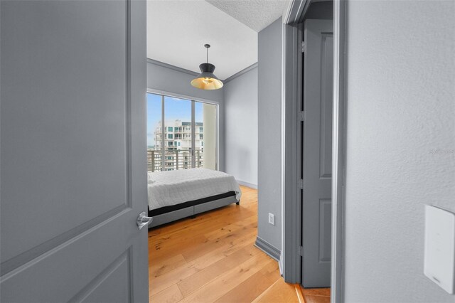 bedroom with light wood-type flooring and a textured ceiling