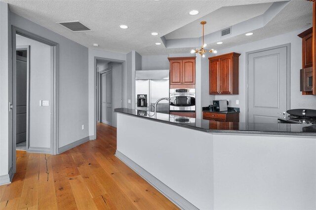 kitchen featuring light hardwood / wood-style flooring, a textured ceiling, and stainless steel appliances