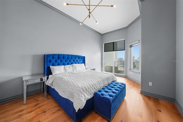 bedroom featuring access to outside, a chandelier, hardwood / wood-style flooring, and ornamental molding