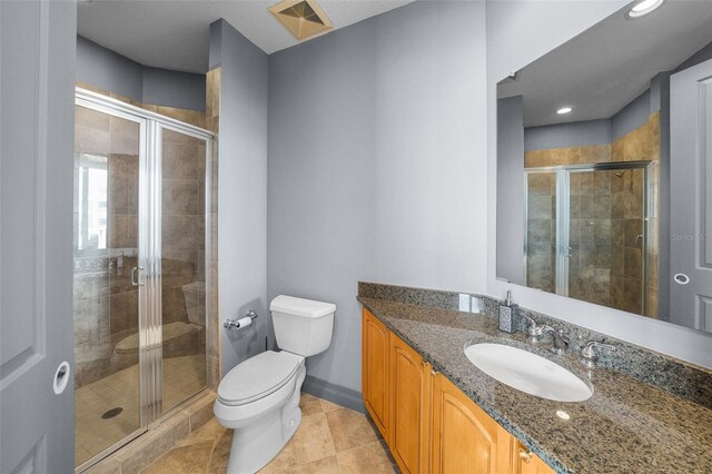 bathroom with walk in shower, vanity, and toilet