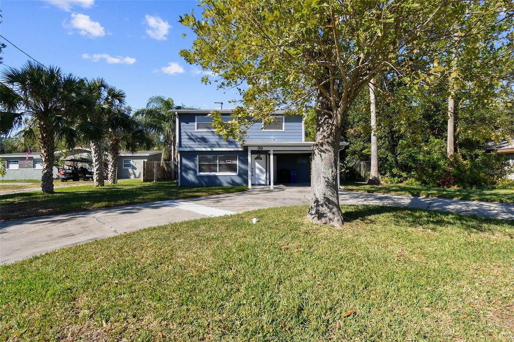 view of front facade featuring a carport and a front lawn