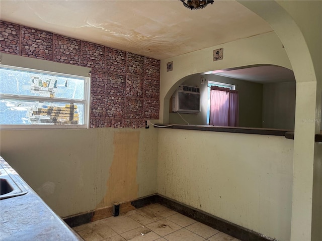 unfurnished room featuring an AC wall unit and sink