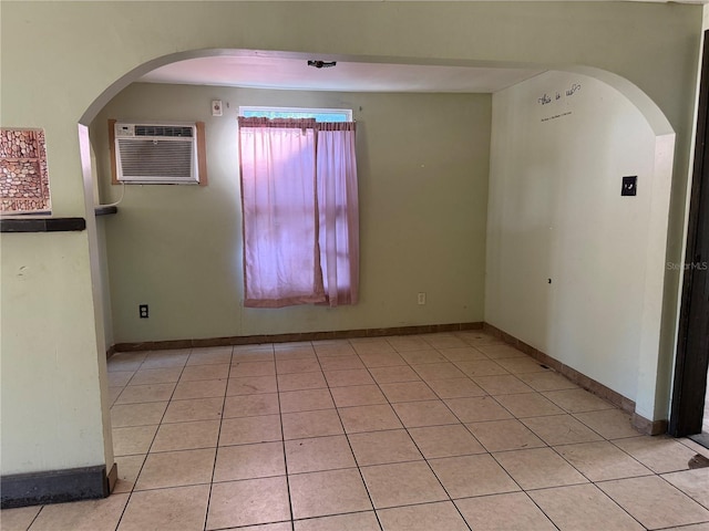 empty room featuring light tile patterned flooring and a wall unit AC