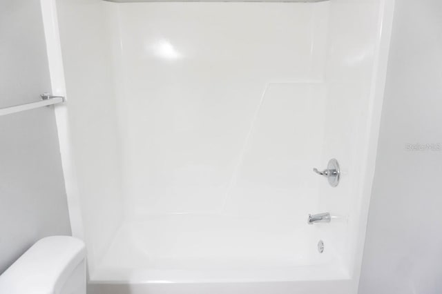 bathroom with toilet and tub / shower combination
