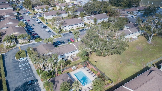 aerial view of property and surrounding area featuring a pool and nearby suburban area