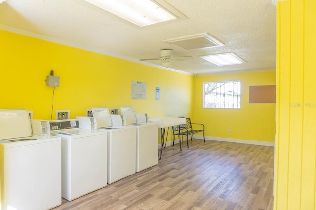 shared laundry room featuring crown molding, light wood-type flooring, a textured ceiling, washer and dryer, and baseboards