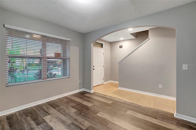 spare room featuring hardwood / wood-style flooring and a textured ceiling