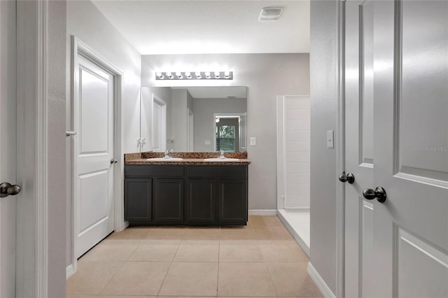 bathroom with vanity, tile patterned floors, and a shower