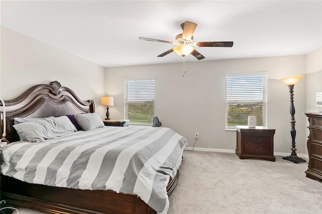 carpeted bedroom with ceiling fan and multiple windows