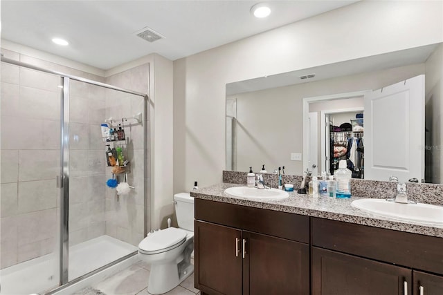 bathroom featuring tile patterned flooring, an enclosed shower, vanity, and toilet