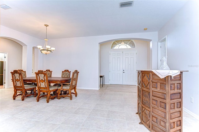 tiled dining space featuring an inviting chandelier