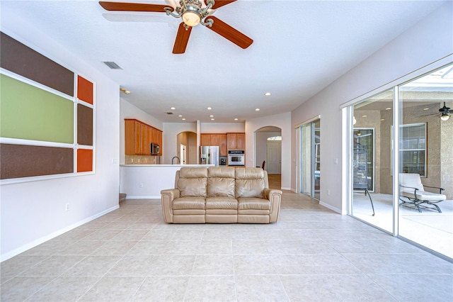 tiled living room with ceiling fan and plenty of natural light