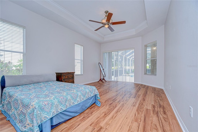 bedroom with hardwood / wood-style floors, access to outside, multiple windows, and ceiling fan