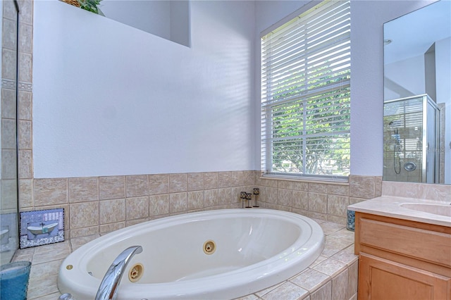 bathroom with vanity and a relaxing tiled tub