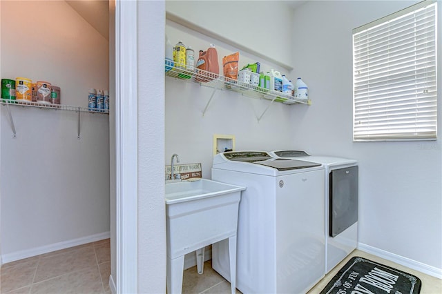 clothes washing area featuring separate washer and dryer, light tile patterned floors, and sink