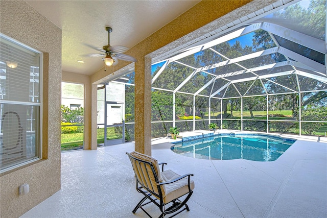 view of swimming pool with ceiling fan, a lanai, and a patio area