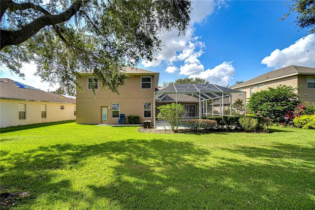 rear view of property with a patio, a yard, and a lanai