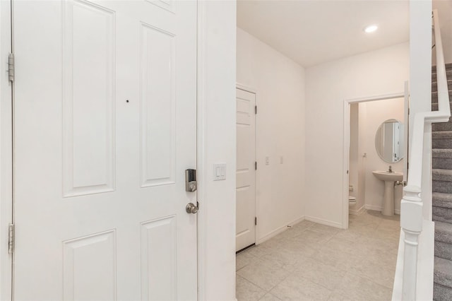 hallway featuring light tile patterned floors and sink