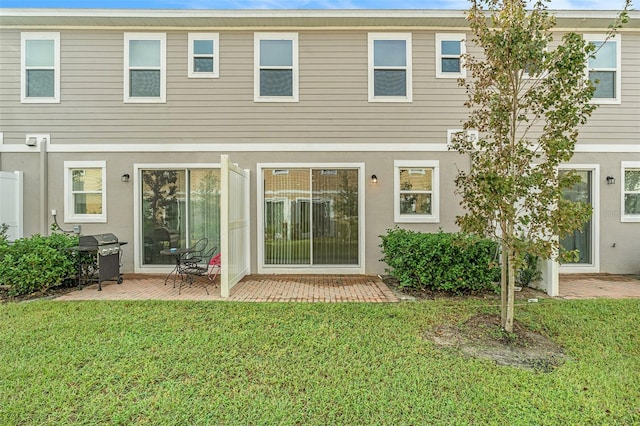 rear view of property featuring a yard and a patio area