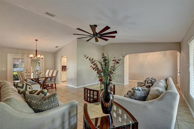 tiled living room with french doors, ceiling fan with notable chandelier, vaulted ceiling, and a healthy amount of sunlight