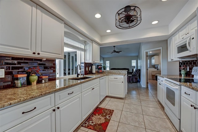 kitchen with sink, tasteful backsplash, kitchen peninsula, white appliances, and white cabinets