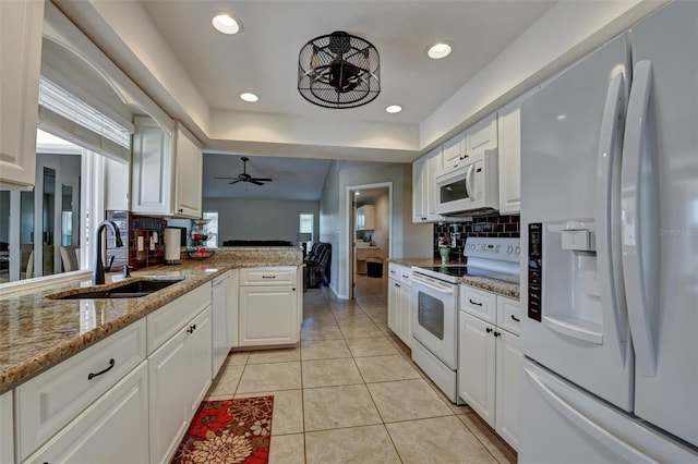 kitchen with kitchen peninsula, white appliances, ceiling fan, sink, and white cabinetry