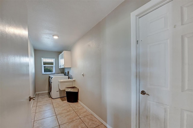 laundry room featuring cabinets, separate washer and dryer, and light tile patterned flooring