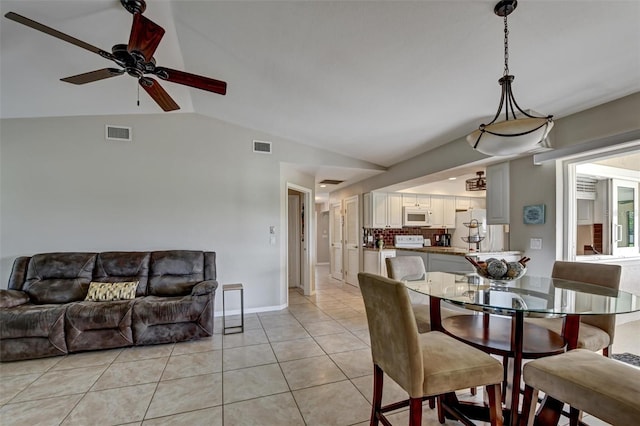 dining area with ceiling fan, light tile patterned floors, and lofted ceiling