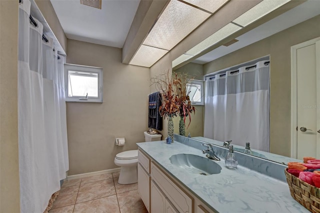 bathroom with toilet, vanity, and tile patterned floors