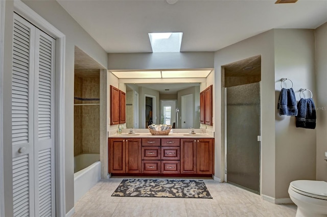 full bathroom featuring vanity, plus walk in shower, a skylight, tile patterned flooring, and toilet