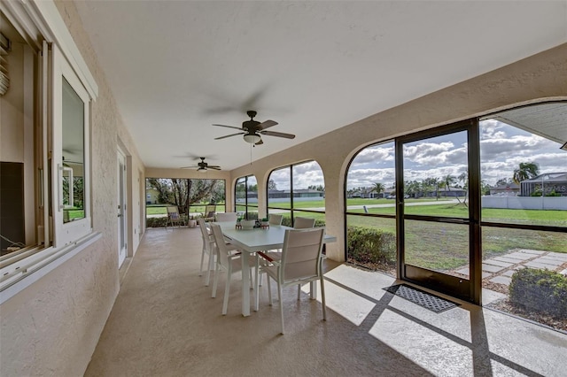 unfurnished sunroom with ceiling fan