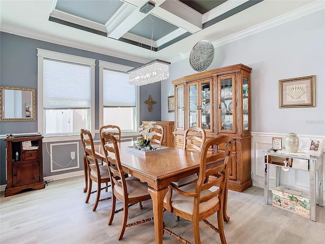 dining space featuring ornamental molding, coffered ceiling, beam ceiling, a chandelier, and light hardwood / wood-style floors